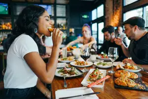 People Sitting At Table Eating Food