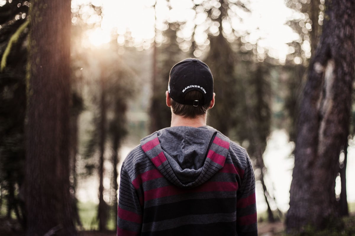 Man standing in a forest facing away