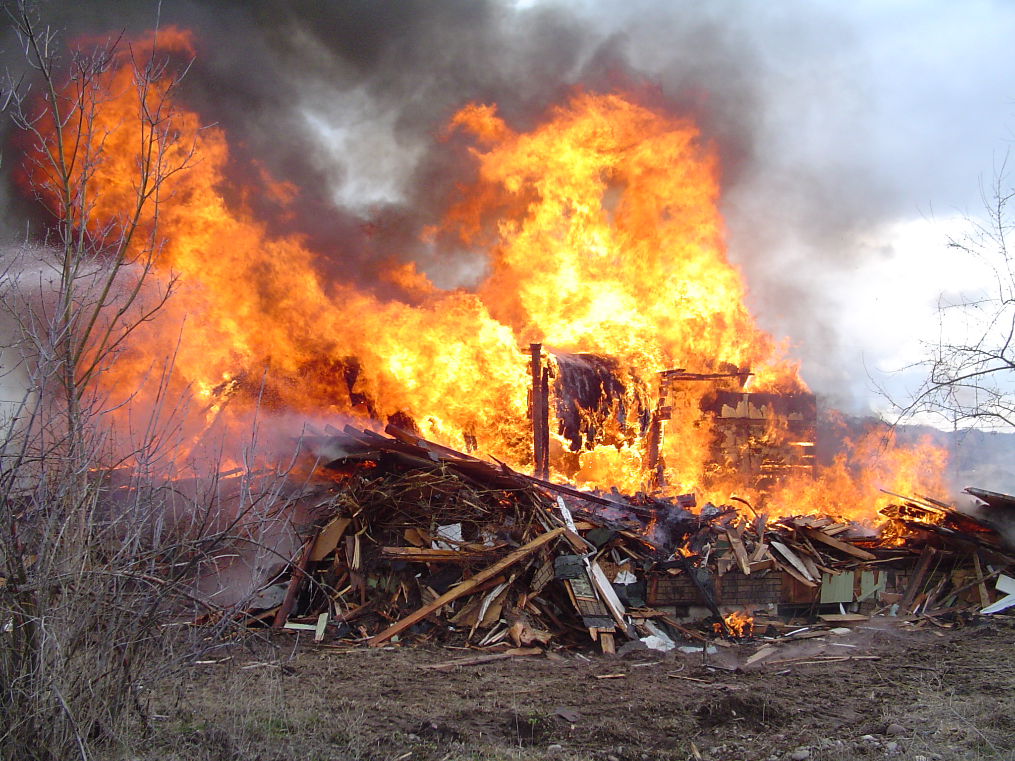 A large fire burning on top of a pile of logs.